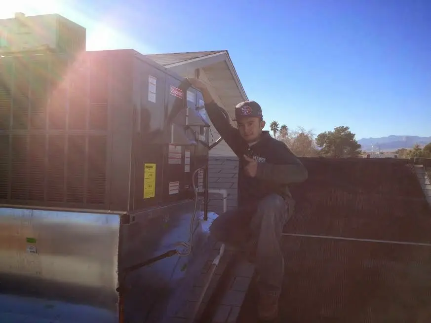 HVAC technician performing Air Duct Repair on a rooftop unit in Prineville